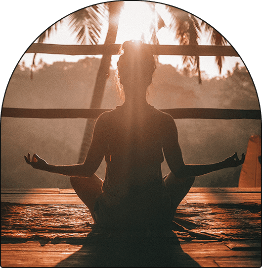 A woman sitting in the middle of a yoga pose.